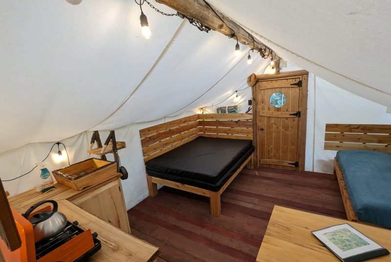the lounge area of our prospector tent, view of the bed, sofa and kitchen